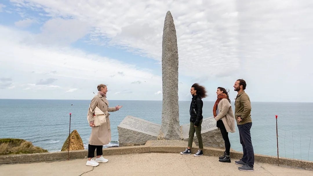 Tourists with guide at Pointe Du Hoc Ranger memorial, Omaha Beach, Normandy.