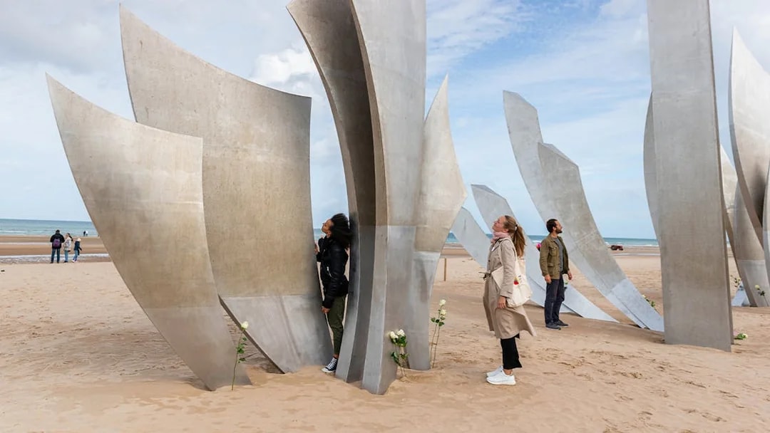 Tour group exploring Les Braves Memorial on Omaha Beach, Normandy.
