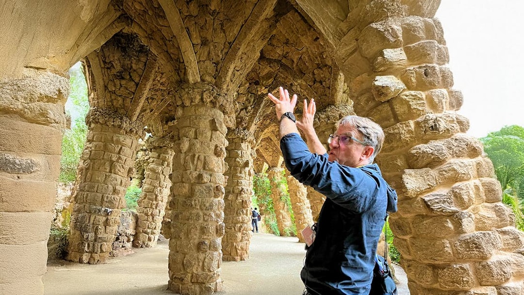 Guide explaining stone columns in Park Guell during a tour in Barcelona, Spain.
