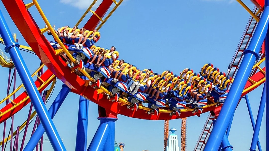 Visitors riding a colorful roller coaster at Parque Warner Madrid.