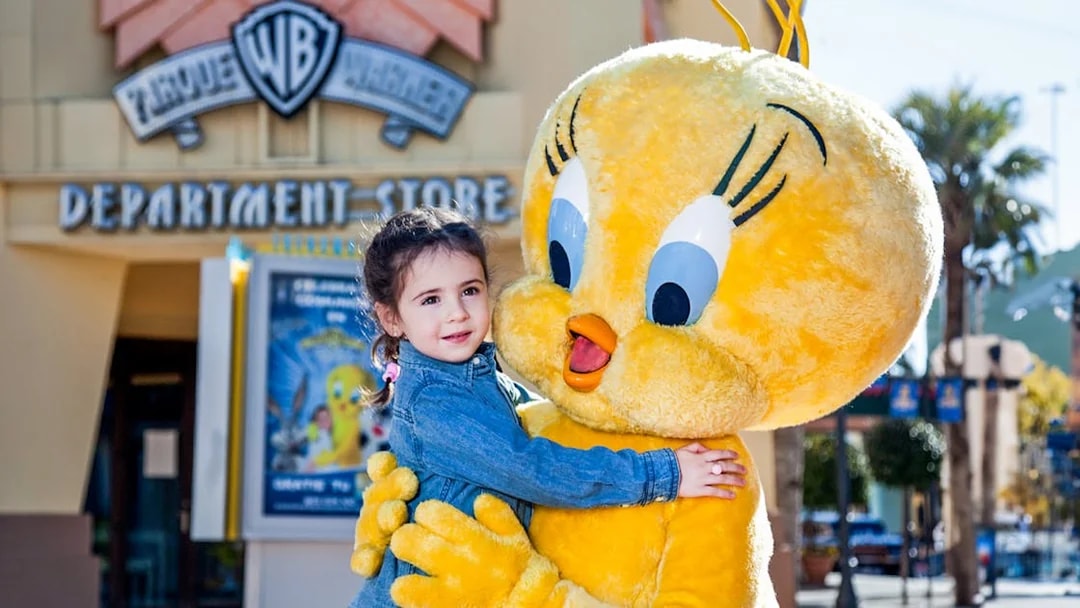 Child hugging Tweety character at Parque Warner Madrid.
