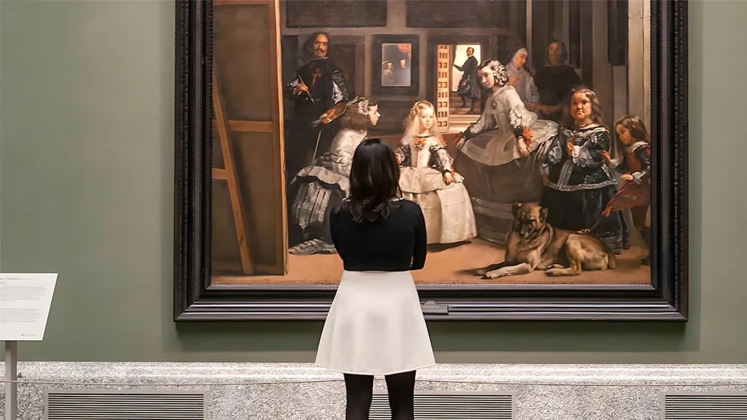 Visitor admiring Velázquez's "Las Meninas" at the Prado Museum in Madrid.