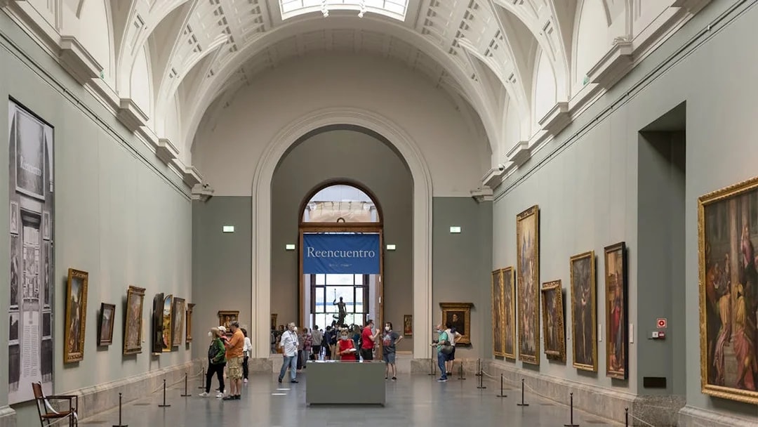 Tourists viewing art inside Prado Museum, Madrid day tour.