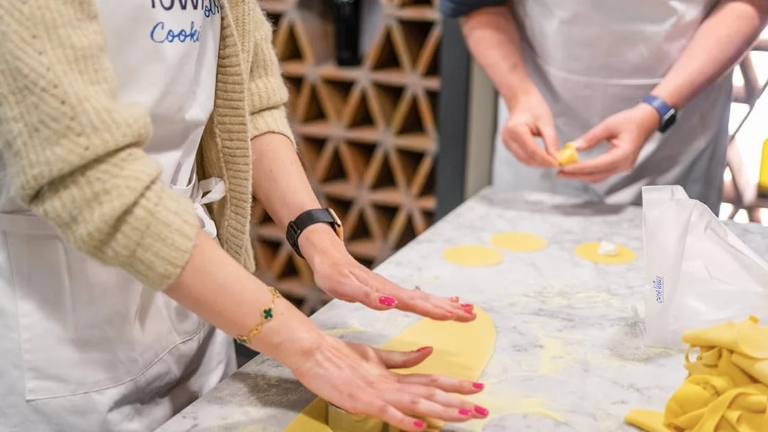 Hands preparing pasta dough at a cooking class in Rome.