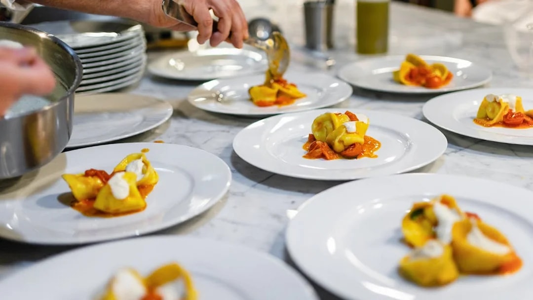 Freshly made fettuccine being plated at a Rome cooking class.
