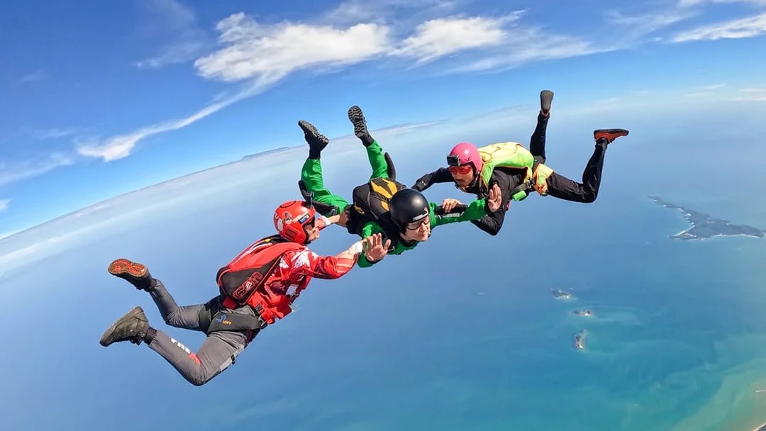 Tandem skydivers freefalling over ocean near Pattaya, Thailand.
