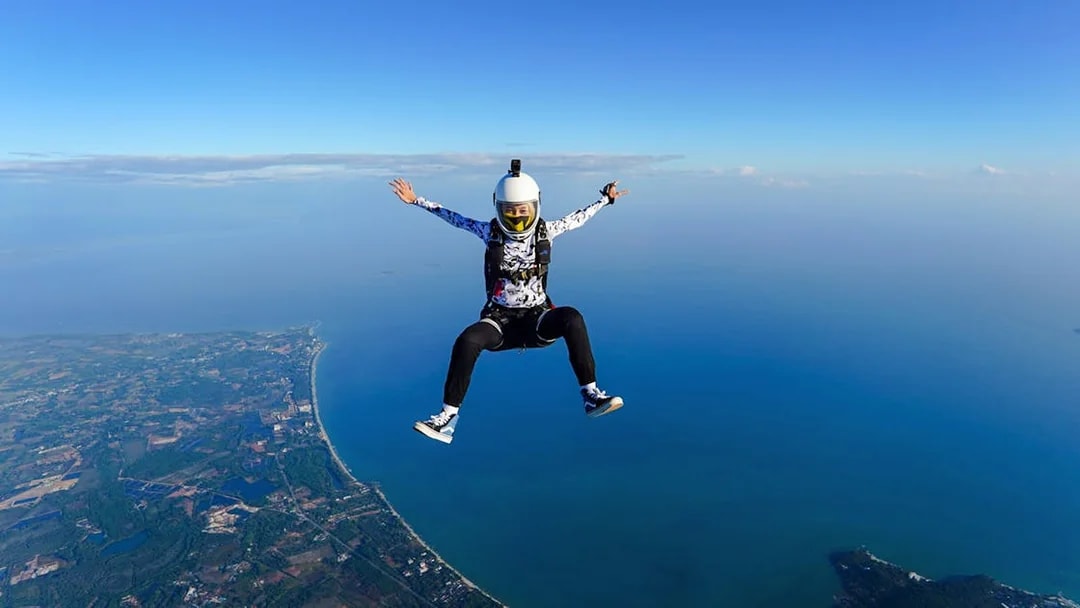 Skydiver over Pattaya coastline during Ocean View Tandem Skydive at 13,000 ft.
