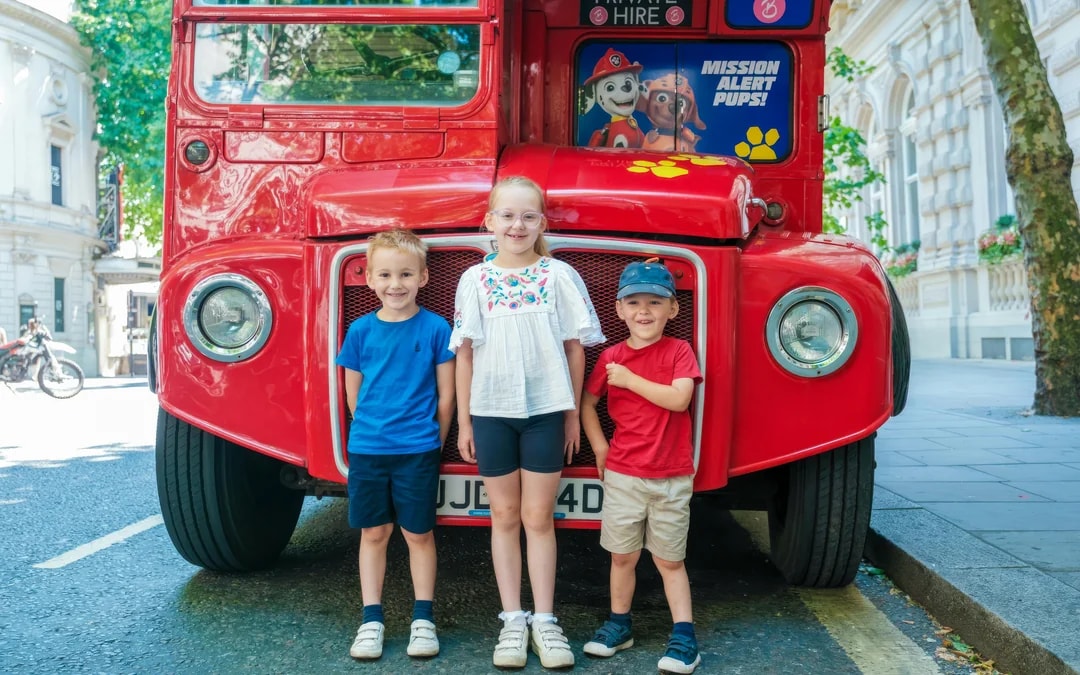 Children standing in front of Paw Patrol themed Brigit’s Afternoon Tea Bus in city street.
