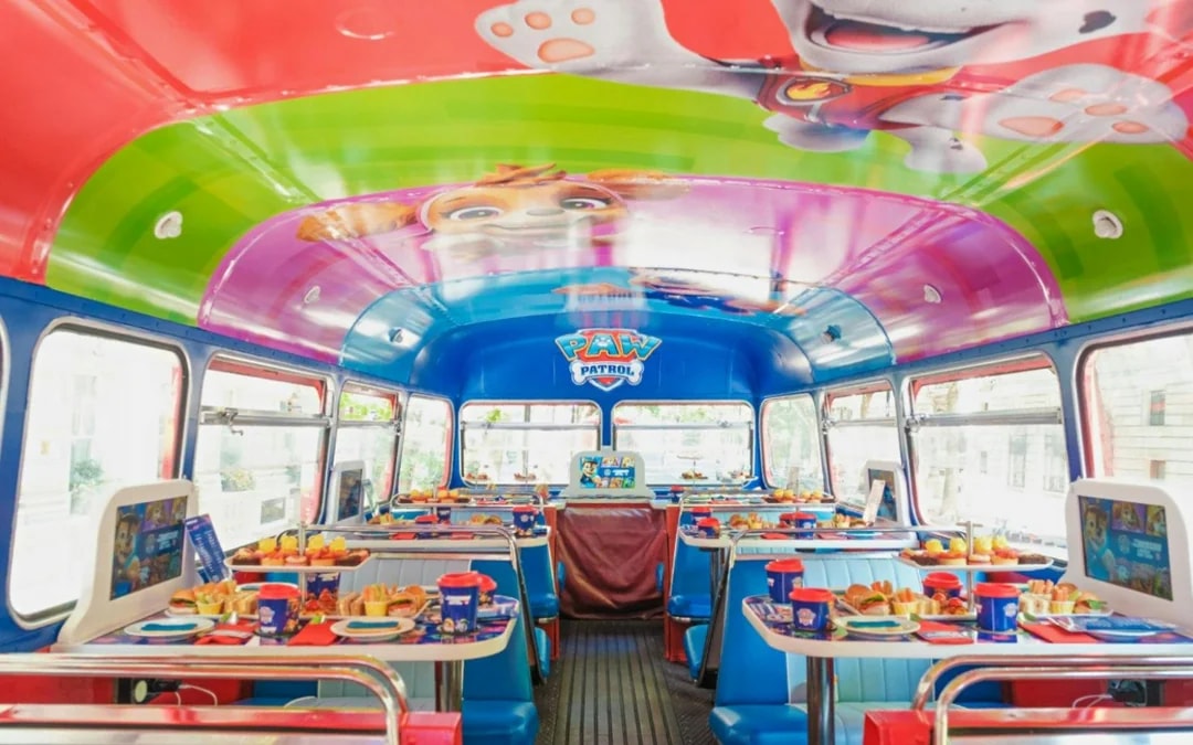 Paw Patrol themed interior of Brigit’s Afternoon Tea Bus Tour with tables set for dining.