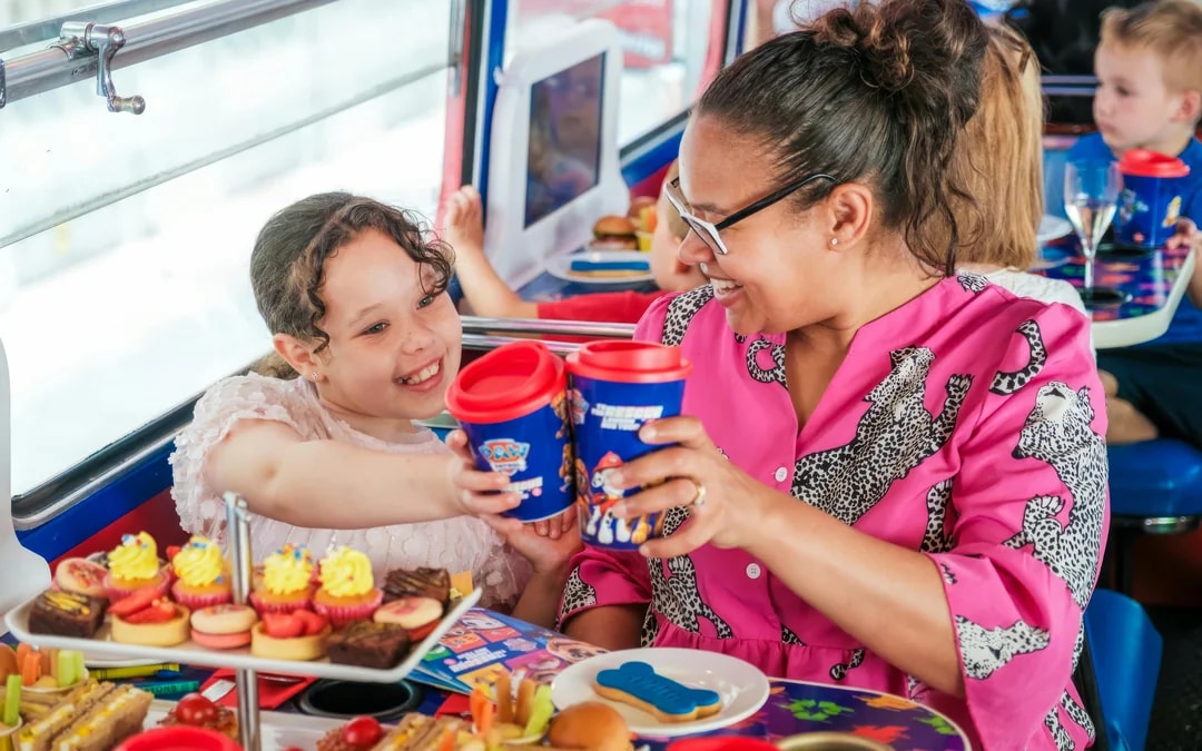 Kids and parents enjoying snacks aboard the Paw Patrol bus.