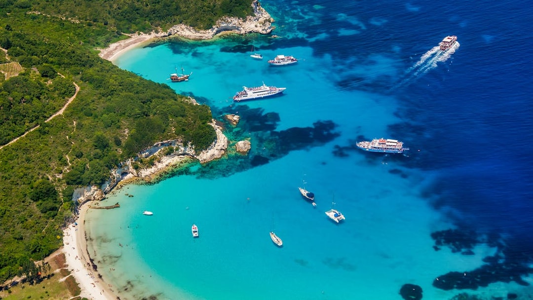 Cruise ships and boats in turquoise waters near Paxos and Antipaxos islands, Greece.