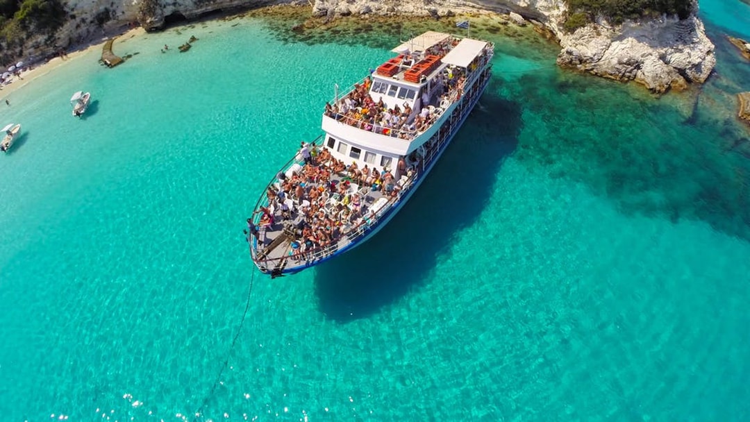 Cruise ship with tourists in turquoise waters near Paxos and Antipaxos.