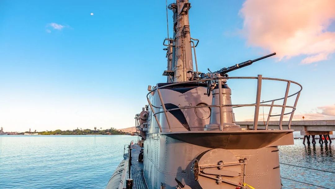 USS Bowfin Submarine docked at Pearl Harbor with clear sky and water.