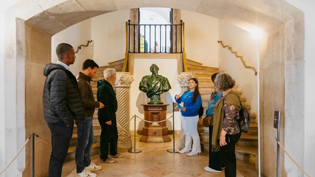 Tour group listening to a guide near a statue inside Pena Palace.