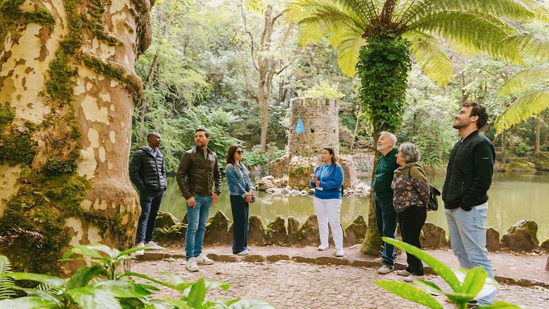 Group of tourists exploring gardens during Pena Palace guided tour in Sintra, Portugal.