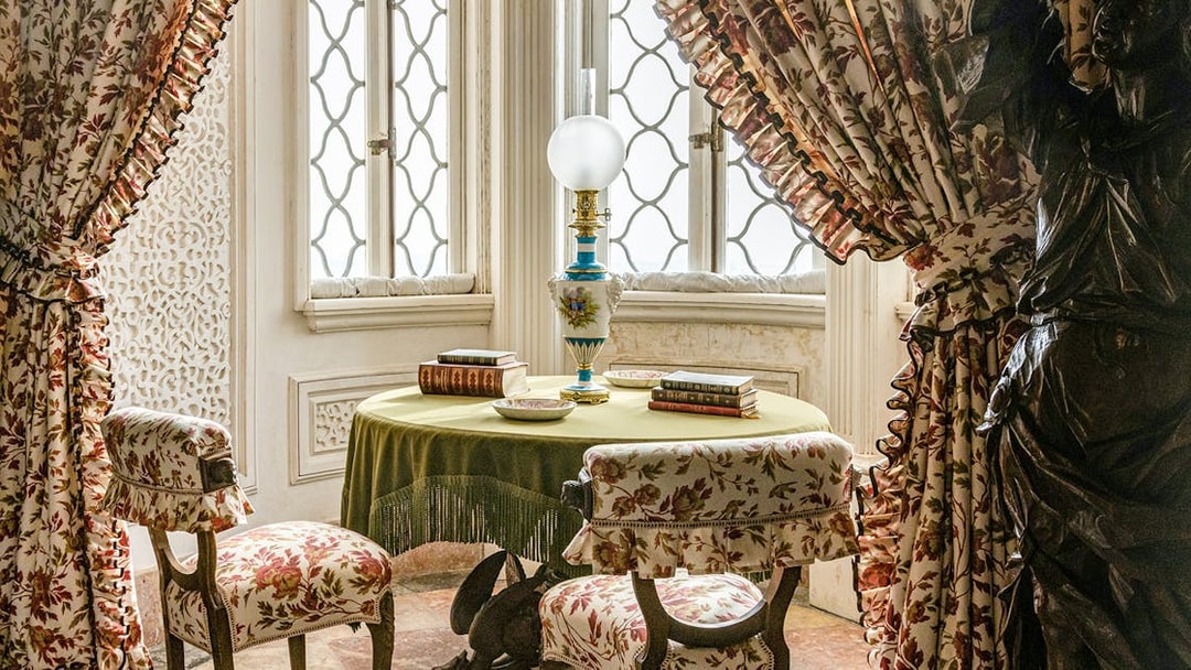 Table with books and lamp in a decorated room, Pena Palace, Portugal.