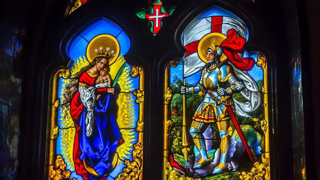 Stained glass window at National Palace of Pena depicting religious figures and knight.