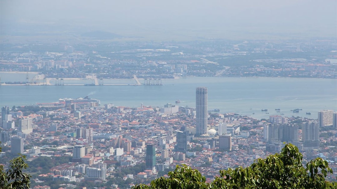 Aerial view of George Town from Penang Hill, featuring cityscape and coastline.