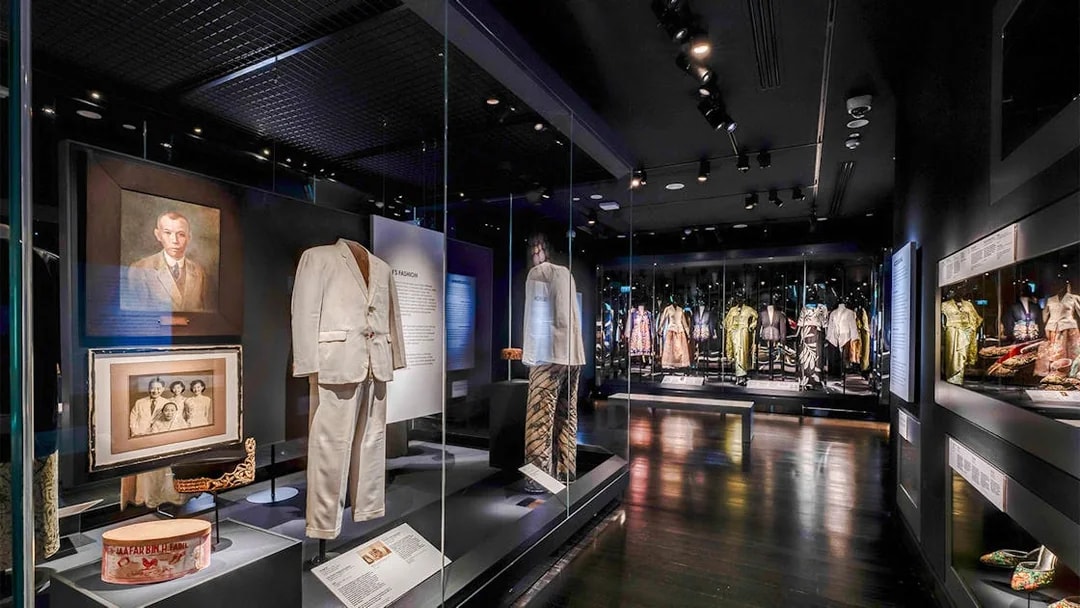 Peranakan Museum gallery showcasing traditional clothing and historical portraits.