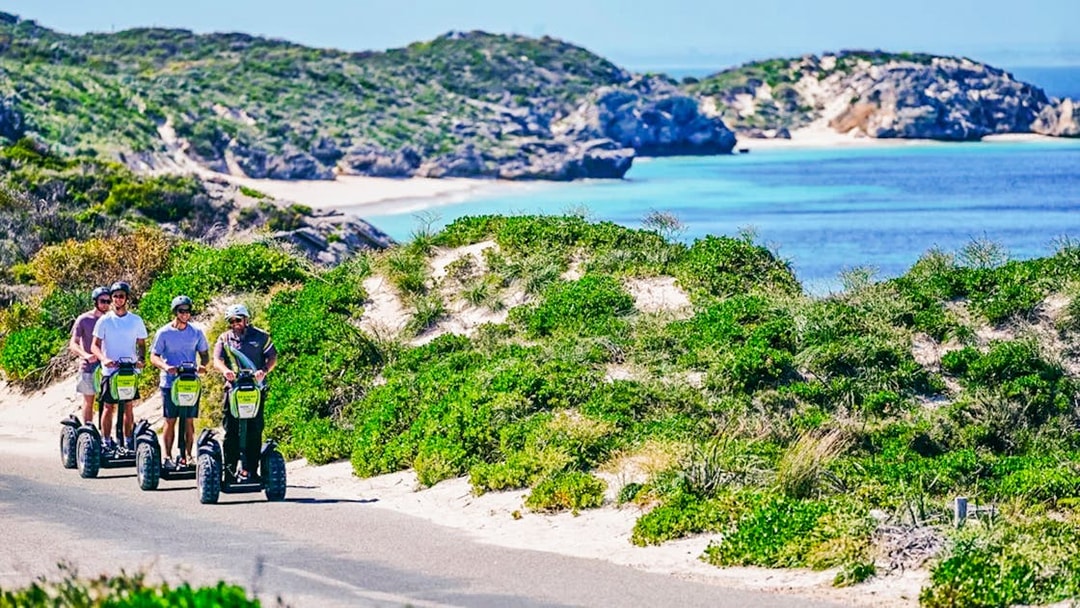 Segway tour group exploring Rottnest Island coast with ocean view.