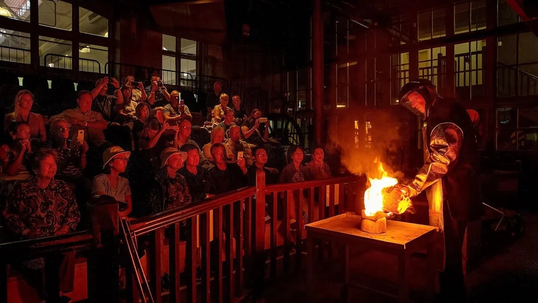 Audience watching a live metal pouring demonstration in Perth.