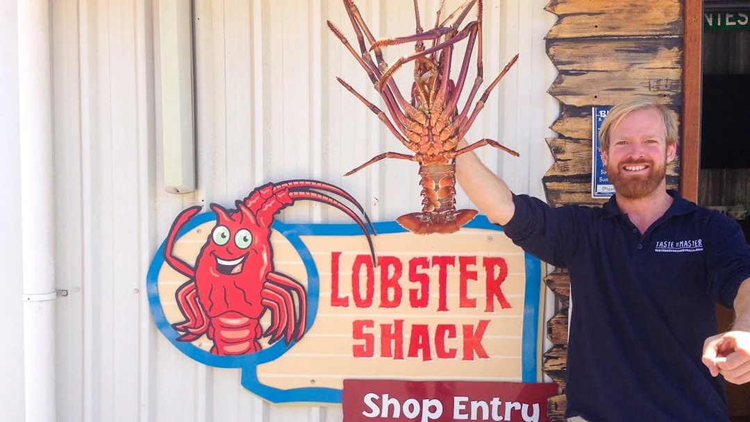 Lobster Shack entry sign with a person holding a large lobster, part of the Pinnacles tour from Perth.