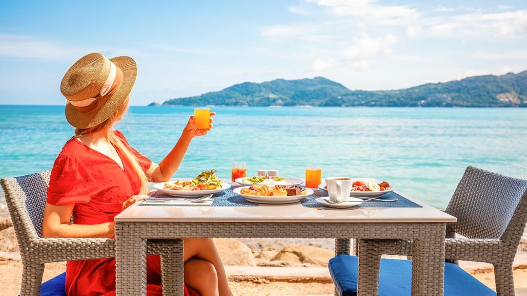 Woman enjoying lunch with ocean view on Phuket Sunset Tour, Phi Phi Island.