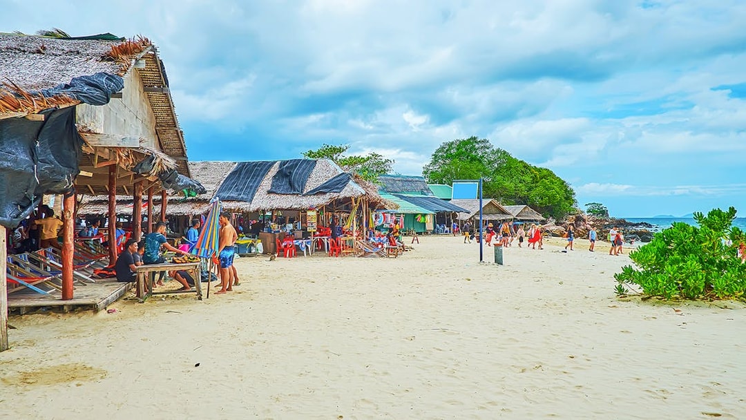 Beachfront huts and tourists on Khai Island, part of the Phi Phi and Maya tour from Phuket.