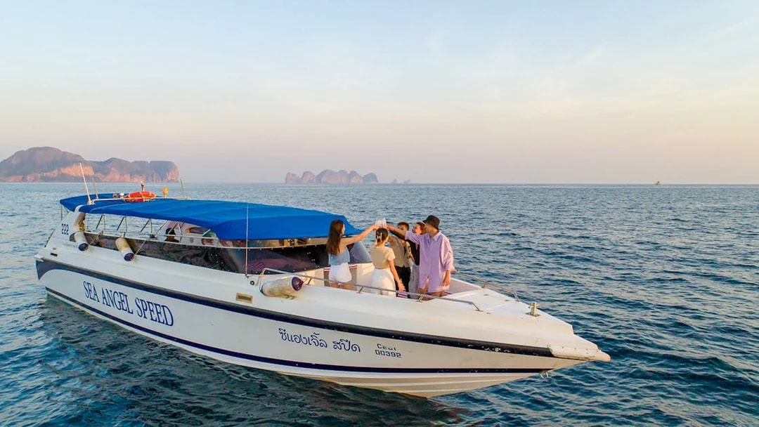 Speedboat with tourists near Phi Phi Islands, Thailand, enjoying the view.