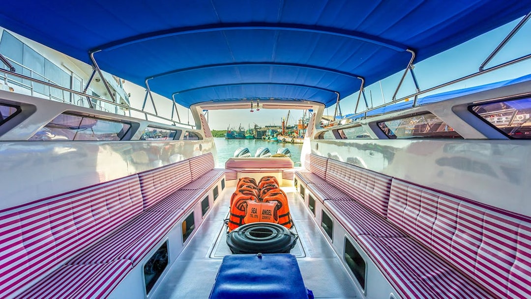 Interior of a speedboat with striped seating and life jackets, departing from Phuket.