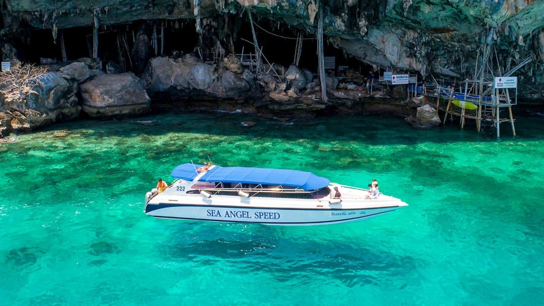 Speedboat near rocky shore of Khai Nai Island, Phuket.