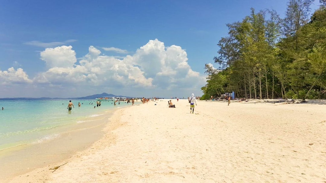 People enjoying the beach and swimming at Nui Beach, Phuket.