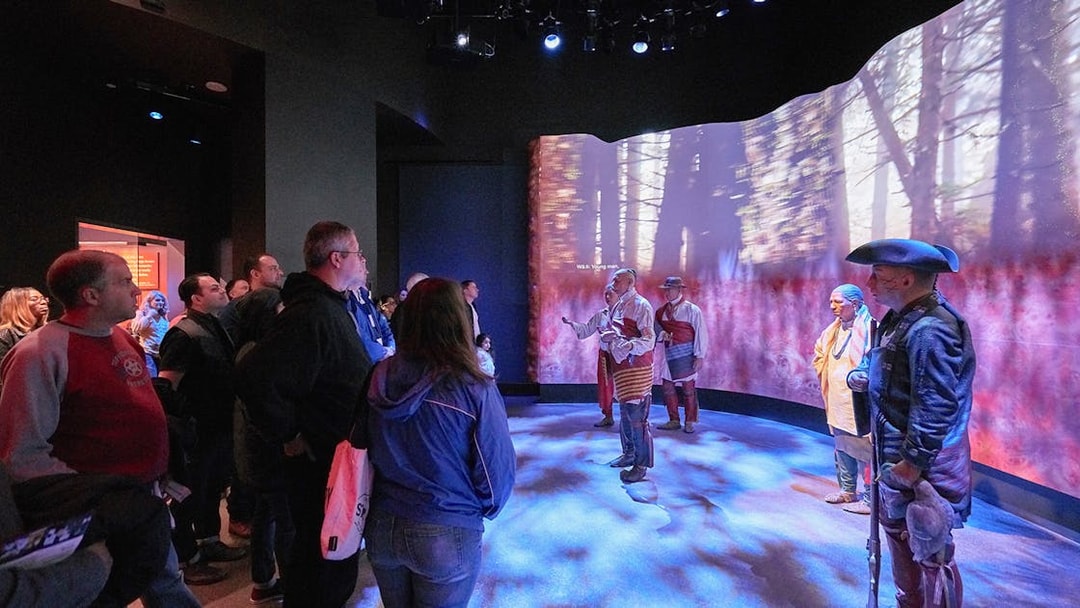 Visitors observing a historical reenactment at the Museum of the American Revolution.