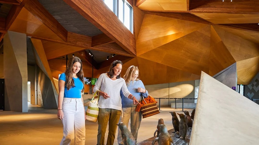 Visitors observing penguin sculptures at Penguin Parade Visitor Centre.