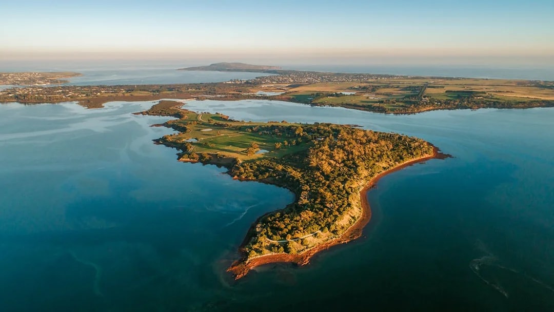 Aerial view of Churchill Island surrounded by water and lush greenery.