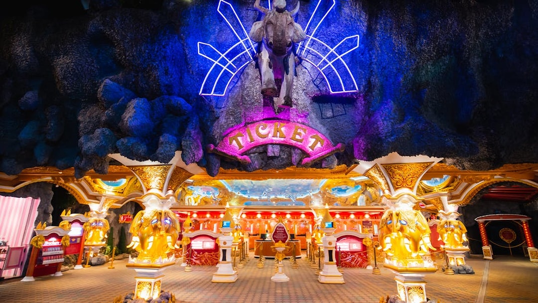 Phuket Fantasea entrance with neon lights and ticket booths.