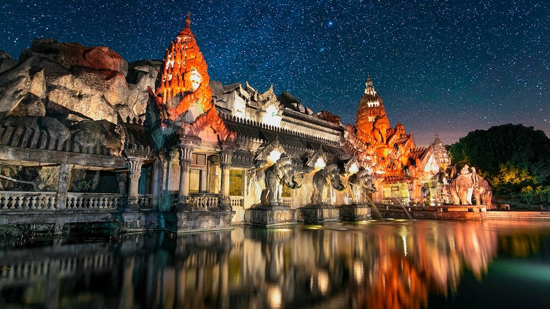Palace Court at Phuket Fantasea illuminated at night with elephant statues and starry sky.
