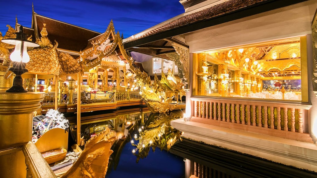Golden Kinnaree Buffet Restaurant at Phuket Fantasea, featuring ornate golden architecture and reflections in water.