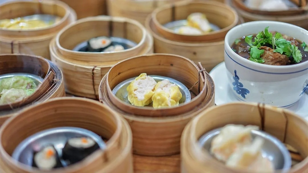 Dim sum baskets and a bowl of soup on a table during a Phuket guided tour.