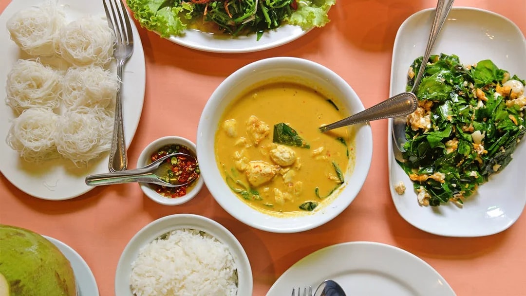 Traditional Thai meal with curry, rice, noodles, and vegetables on a Phuket tour.