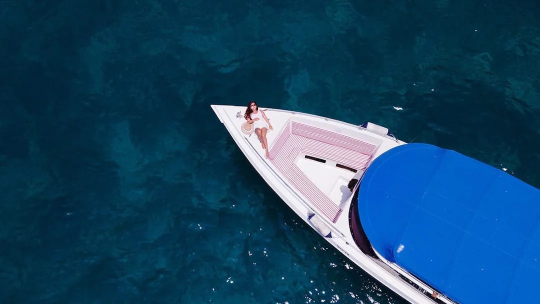 Woman relaxing on a speedboat in clear water near Phi Phi Islands.