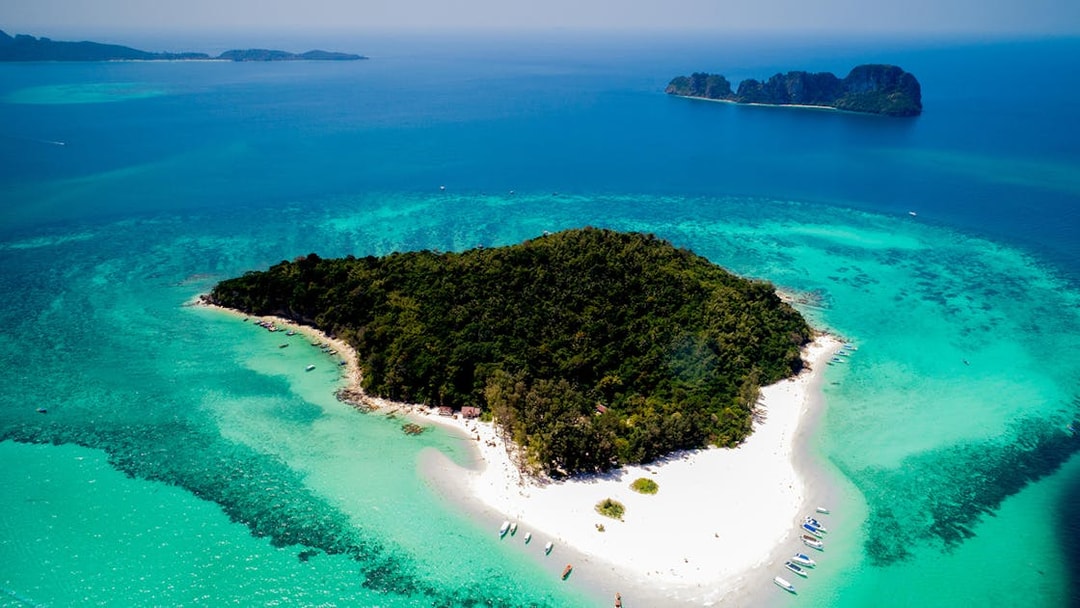 Aerial view of Bamboo Island's lush greenery and white sandy beaches in Thailand.