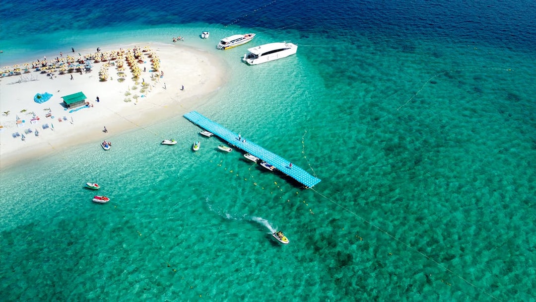 Aerial view of Khai Island beach with boats and pier, Thailand.