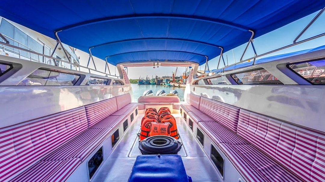 Speedboat interior with striped seats and life vests in Phuket.