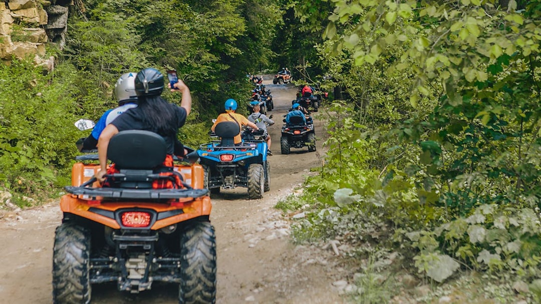 ATV riders on a forest trail during a Phuket adventure tour.