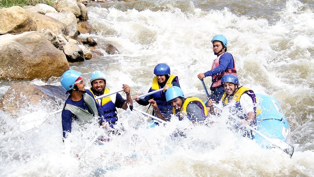 Tourists rafting through rapids in Phuket during a full day adventure.