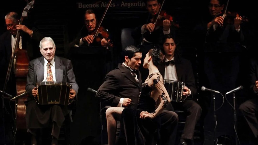 Dancers performing at Piazzolla Tango Show in Buenos Aires with live musicians.