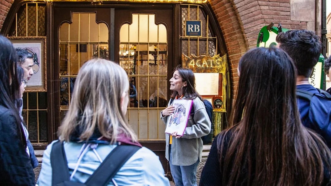 Guide explaining to visitors outside 4 Cats restaurant in Barcelona.