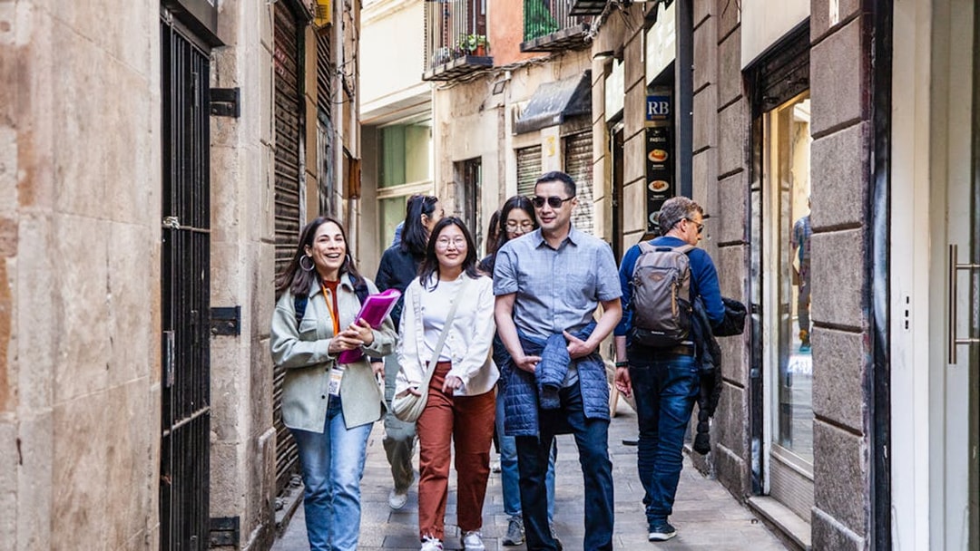 Guests walking with guide through narrow European street.