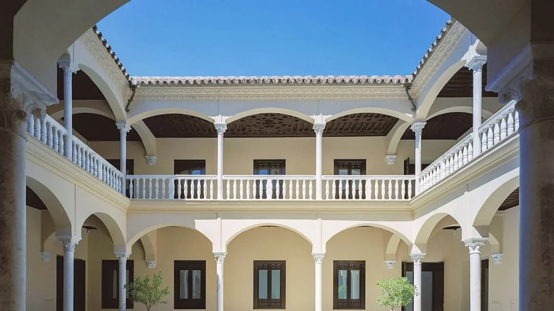 Courtyard of the Picasso Museum in Malaga with arches and columns.